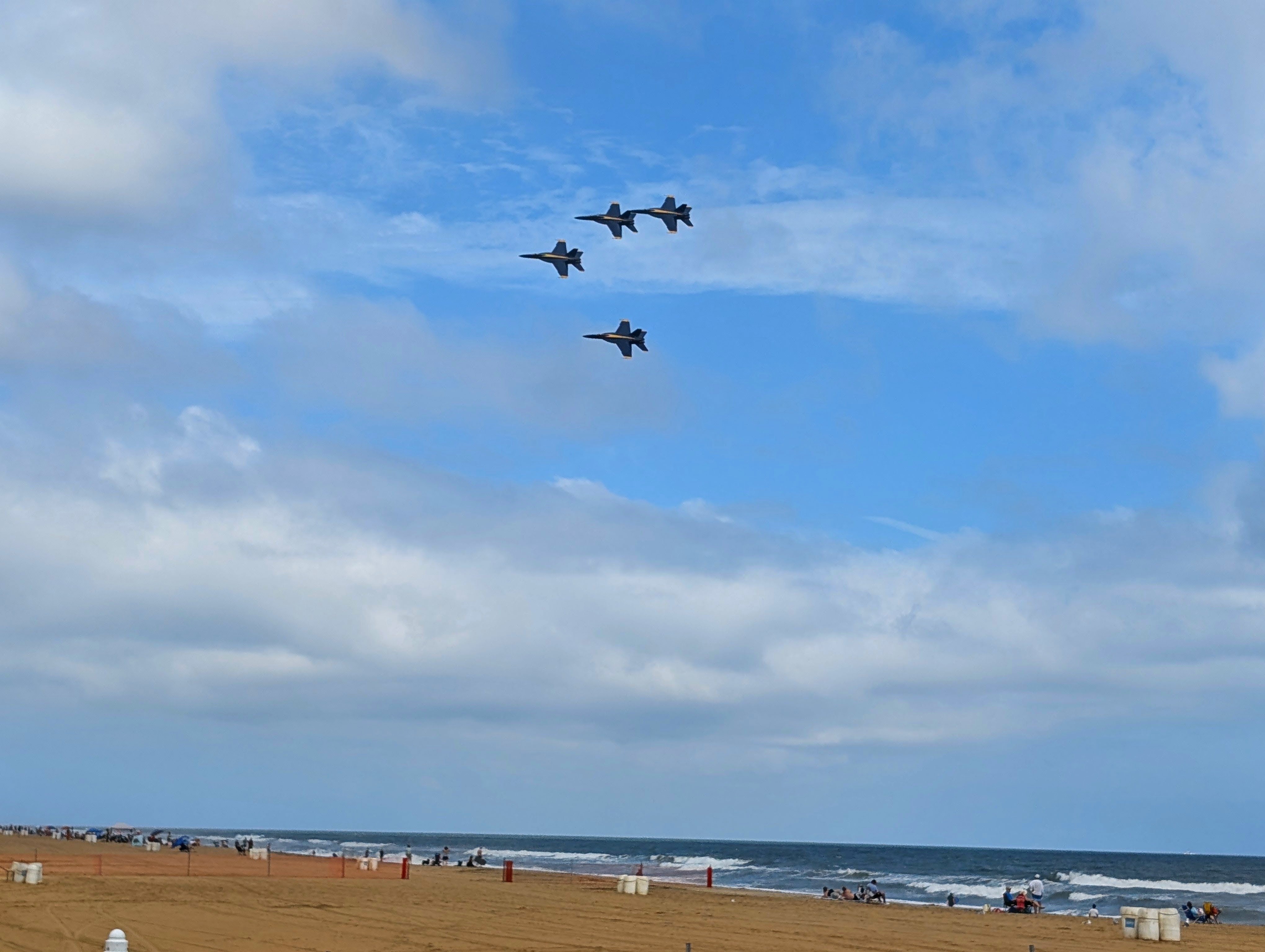 The Blue Angels in formation over a crowded beach